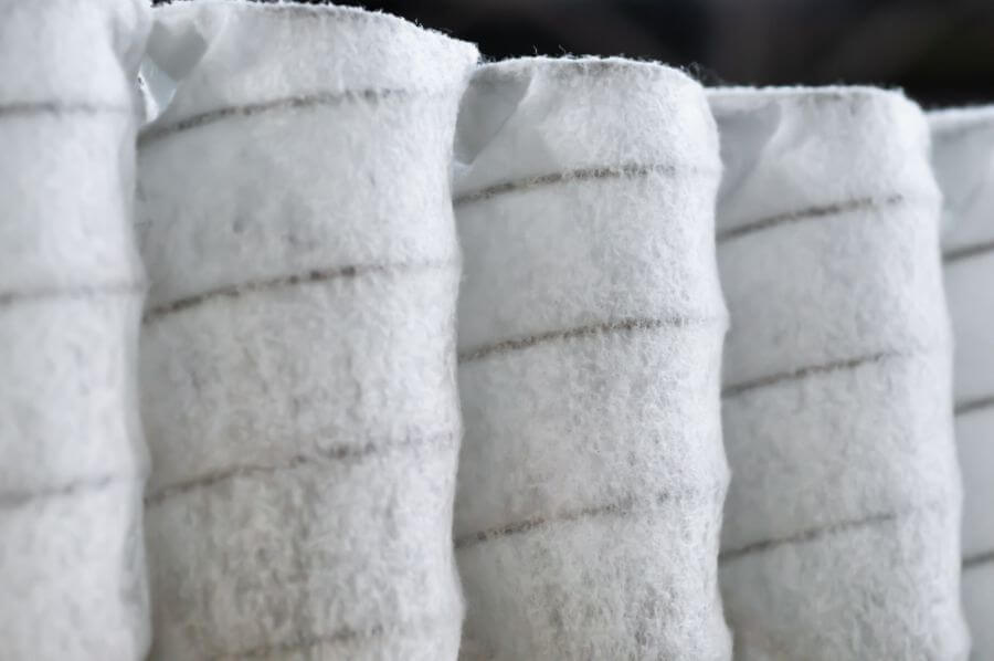 Detail of coiled, soft white filtration fabric, showing texture and layered design.