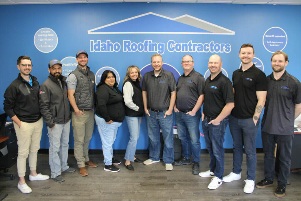 Picture of the Idaho Roofing Contractors team members standing in a line wearing dark tops.