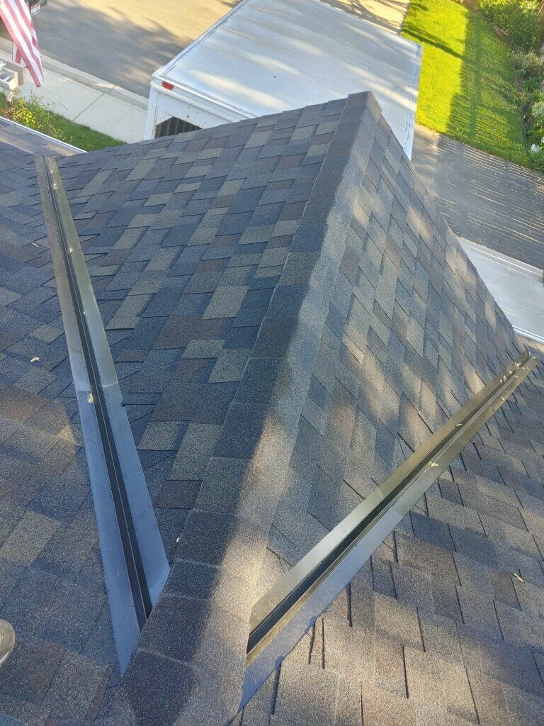 Close-up view of a dark gray shingle roof with a visible ridge vent.
