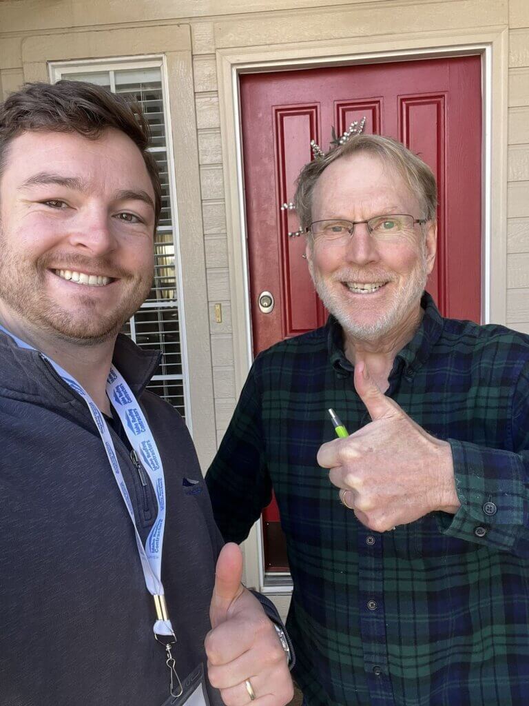Idaho Roofing Contractor associate standing with a happy home owner giving a thumbs up after a job well done.