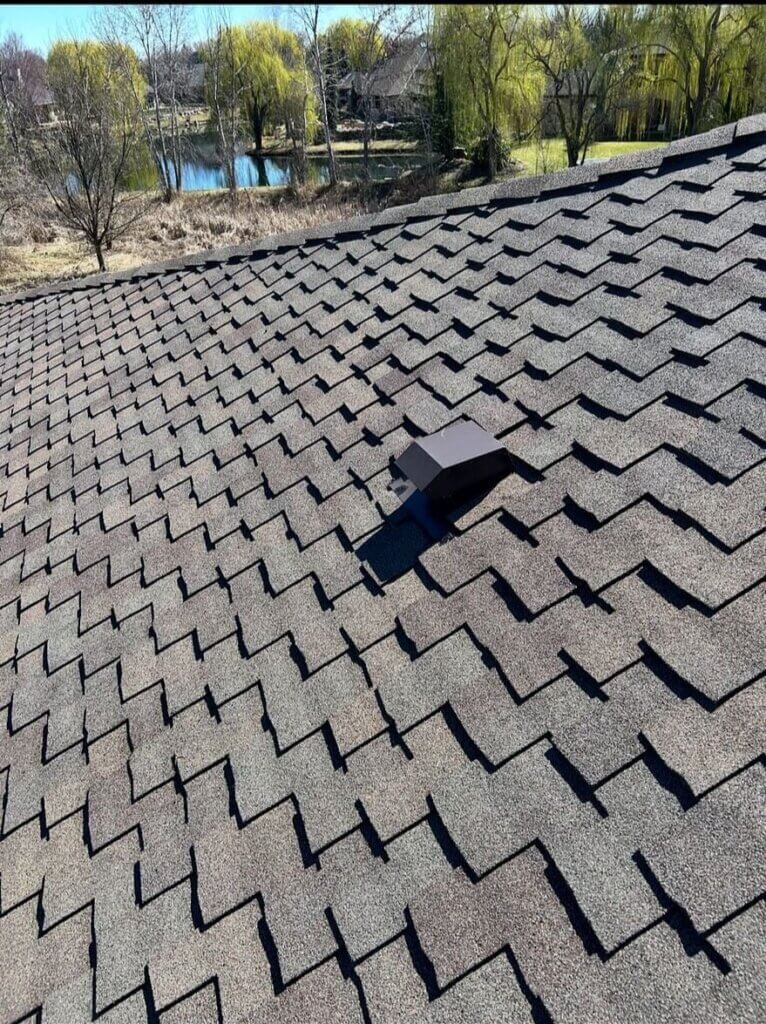 A single roof vent can be seen in the middle of this expert architectural shingle arrangement with strong shadow lines