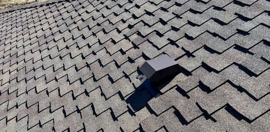 A single roof vent can be seen in the middle of this expert architectural shingle arrangement with strong shadow lines
