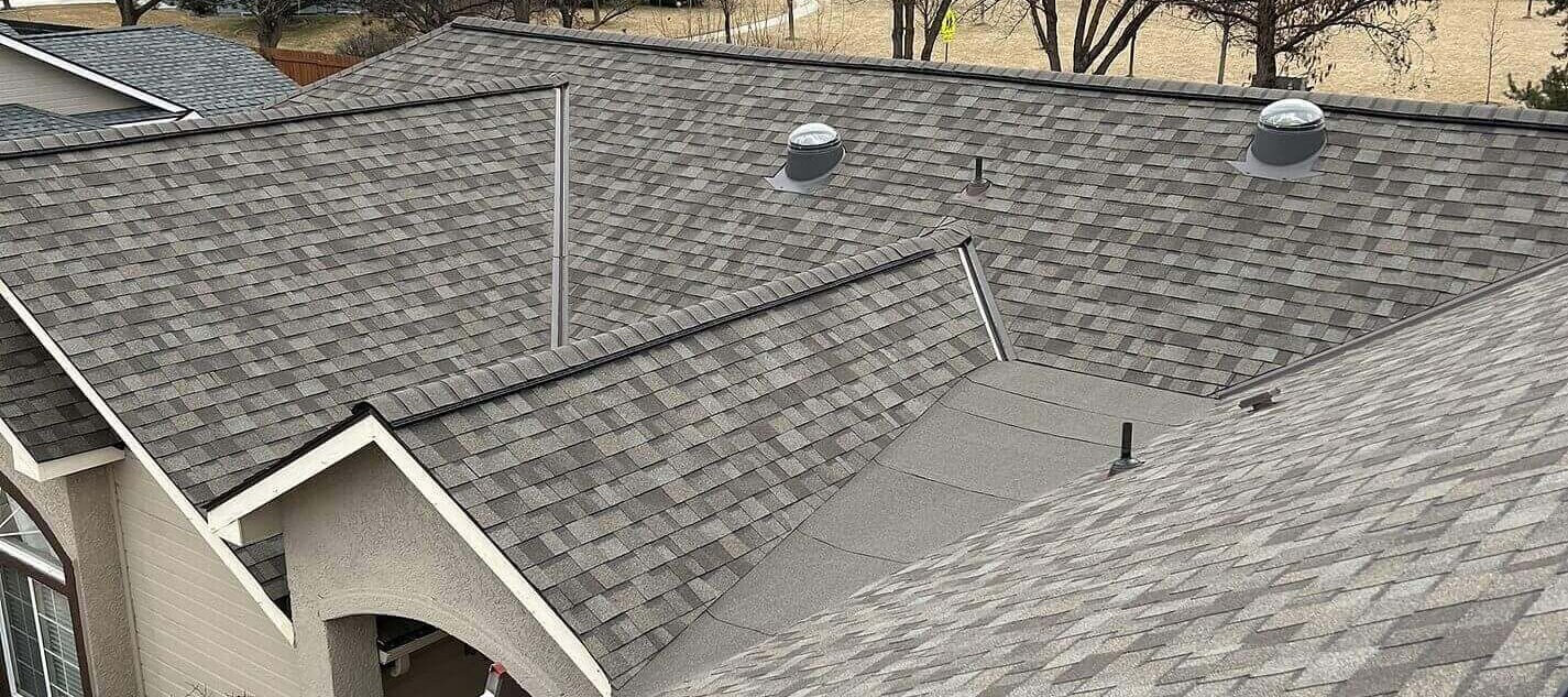 Architectural shingle roof with multiple circular roof vents, consistent ridge lines, and multiple slopes.