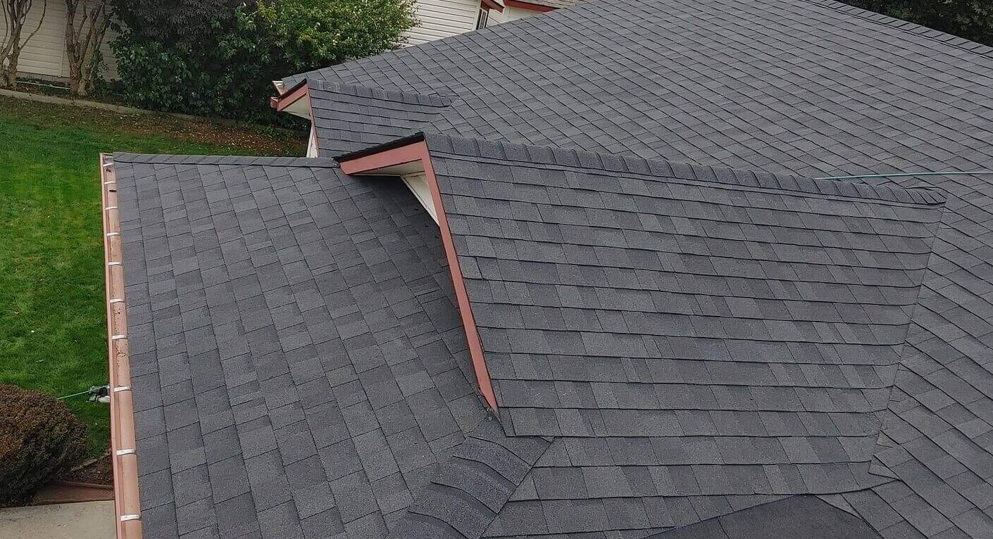 Copper gutters, accurate dormer integration, dark asphalt shingle roof with closed valley.