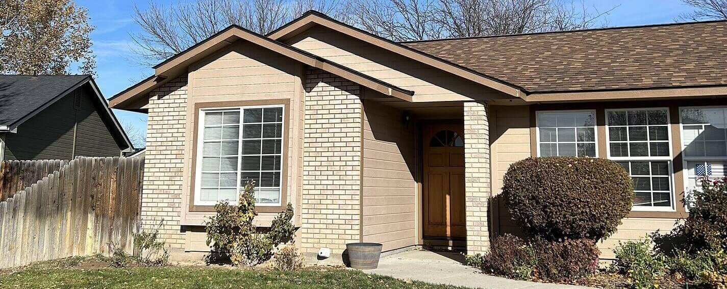 A single-story, front-gable house with brown architectural shingles that have clean valleys and distinct ridge lines.