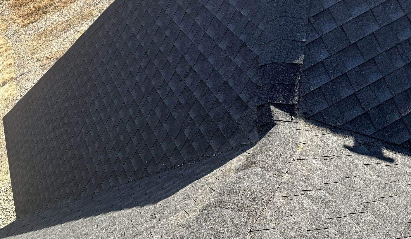 Showcasing consistent shingle alignment and elegant transitions, steep-pitch shingle roof with several hips and valleys exhibits.