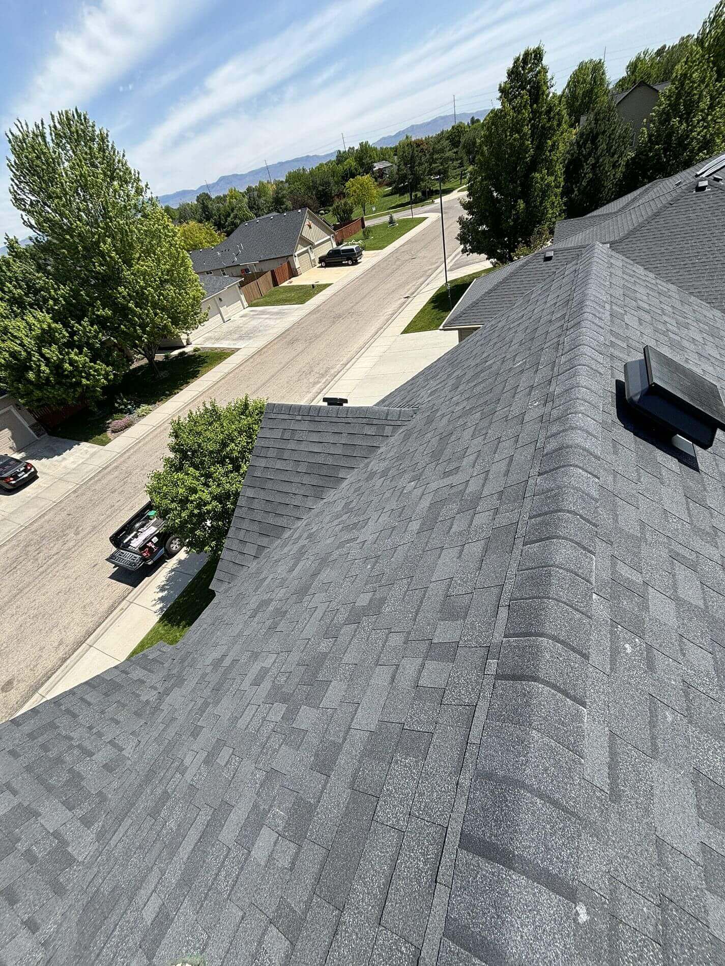 Dark architectural shingles and revised ventilation vents show a rooftop perspective of complete roof renovation in Boise, Idaho.
