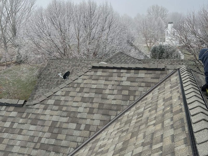 Multi-level roof with tan dimensional shingles and ridge vents.