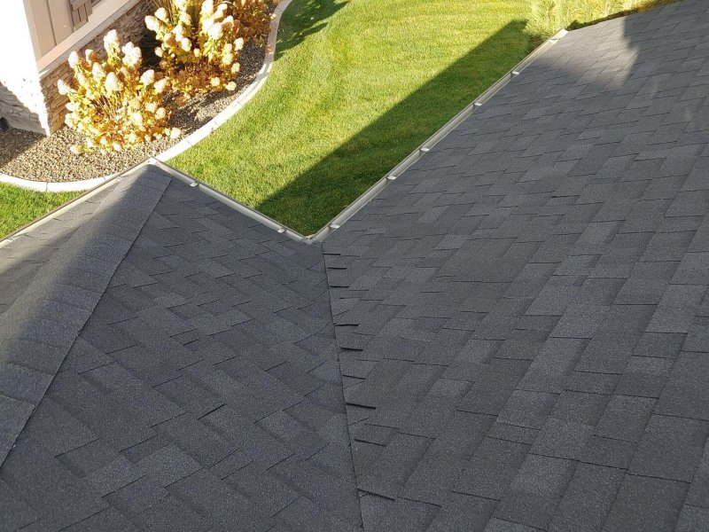 Gray roof shingles meeting at a precise valley intersection.
