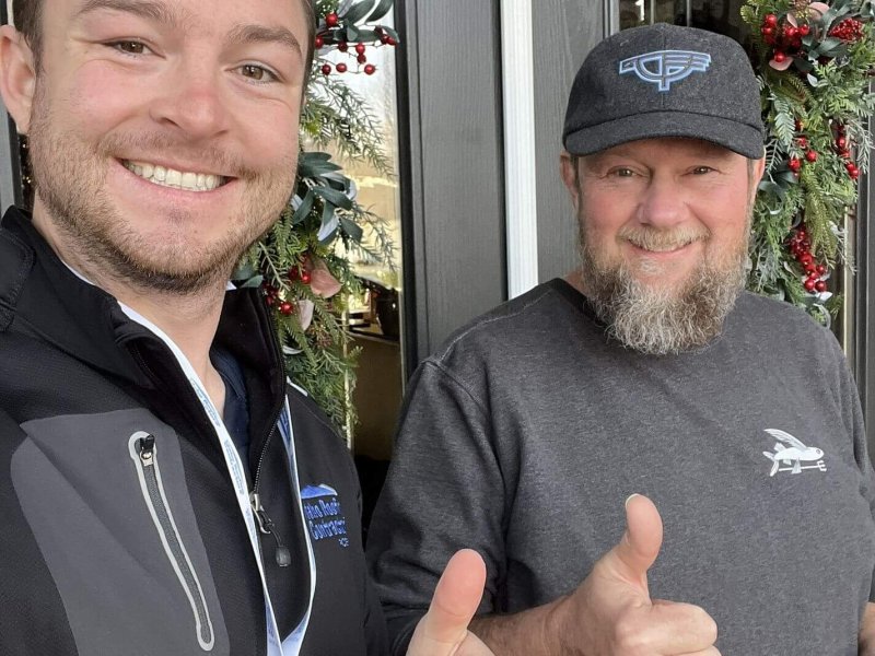 Roofing consultant and satisfied customer giving thumbs up at the doorway or a house.